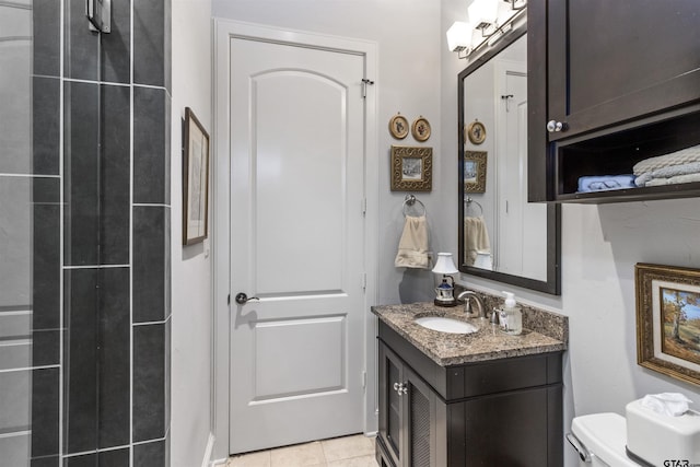 bathroom featuring vanity, tile patterned flooring, and toilet