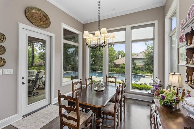 dining room featuring a notable chandelier, dark wood finished floors, ornamental molding, and baseboards