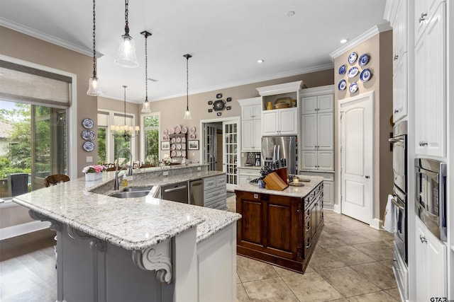 kitchen with a large island with sink, a sink, and a healthy amount of sunlight