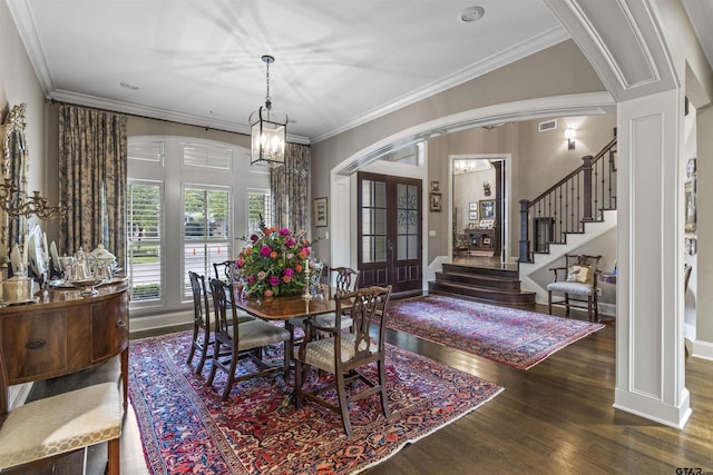 dining area featuring crown molding, arched walkways, french doors, stairs, and wood finished floors