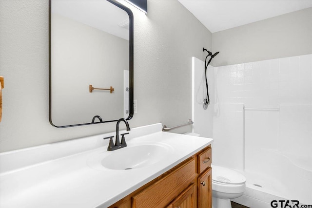 bathroom with toilet, vanity, and a shower