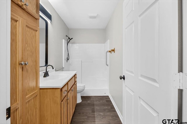 bathroom with walk in shower, vanity, wood-type flooring, and toilet