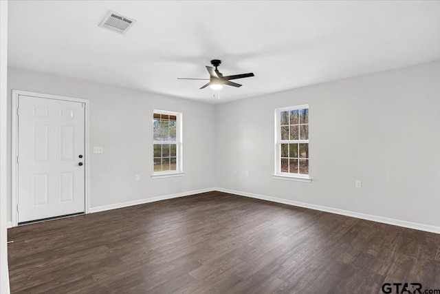 empty room with ceiling fan and dark hardwood / wood-style flooring