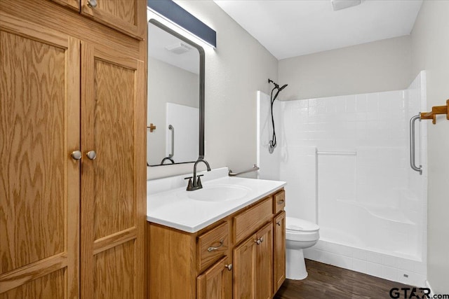 bathroom featuring a shower, hardwood / wood-style floors, toilet, and vanity