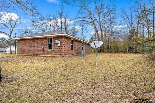 view of home's exterior with cooling unit and a yard