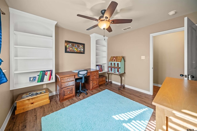 office area featuring a ceiling fan, wood finished floors, visible vents, and baseboards