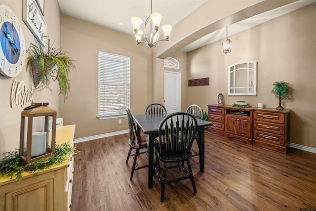 dining space with dark wood finished floors, a notable chandelier, and baseboards