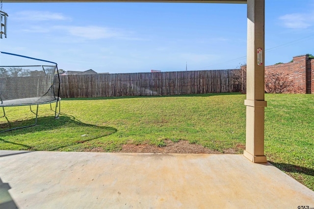 view of yard with a fenced backyard, a patio, and a trampoline