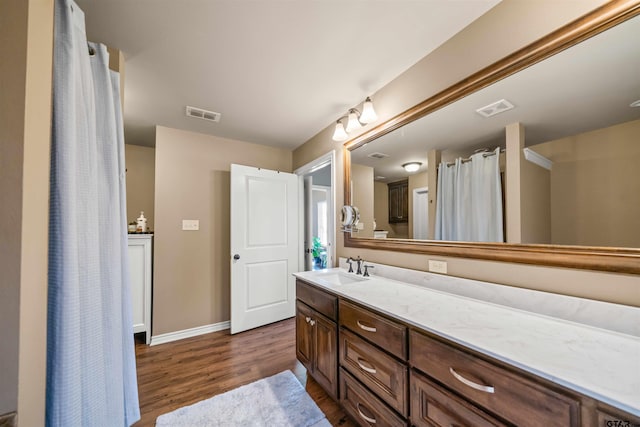 full bathroom with visible vents, baseboards, wood finished floors, and vanity