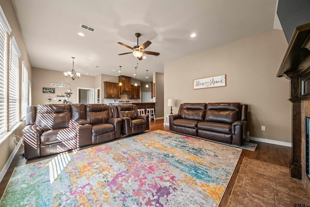 living area with visible vents, baseboards, a fireplace, recessed lighting, and ceiling fan with notable chandelier