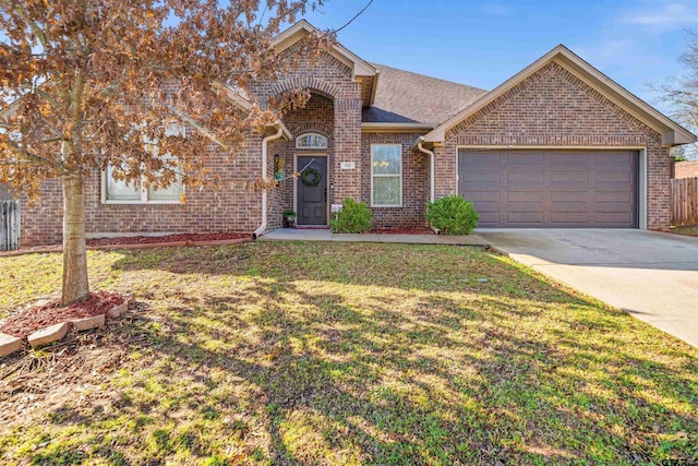 traditional-style home featuring driveway, a front lawn, brick siding, and an attached garage