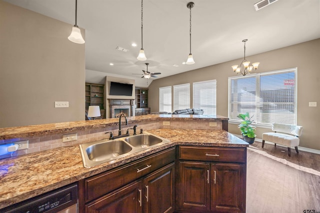 kitchen featuring visible vents, ceiling fan with notable chandelier, a sink, stainless steel dishwasher, and wood finished floors