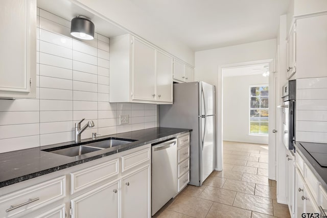 kitchen with white cabinetry, sink, backsplash, dark stone counters, and black appliances