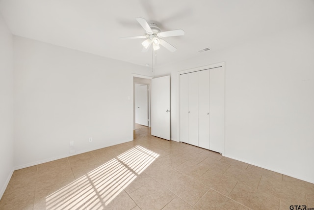 unfurnished bedroom with ceiling fan, light tile patterned floors, and a closet