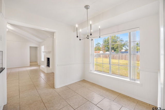 unfurnished dining area with vaulted ceiling with beams, light tile patterned floors, a fireplace, and an inviting chandelier