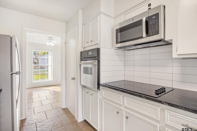 kitchen featuring tasteful backsplash, dark stone counters, ceiling fan, black appliances, and white cabinets