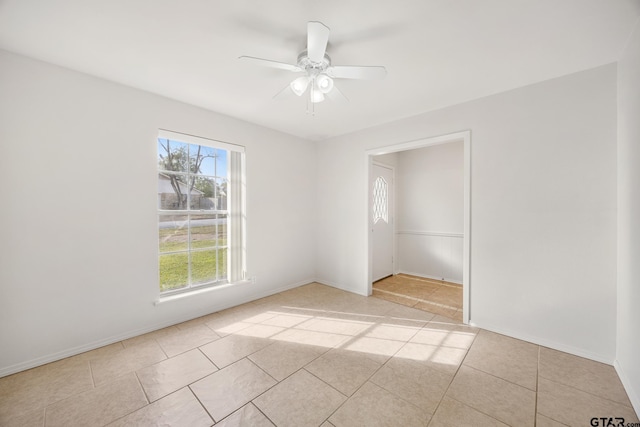 tiled empty room featuring plenty of natural light and ceiling fan