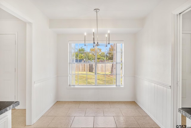 unfurnished dining area with light tile patterned floors and a chandelier