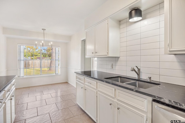 kitchen featuring white cabinetry, sink, tasteful backsplash, stainless steel dishwasher, and a chandelier