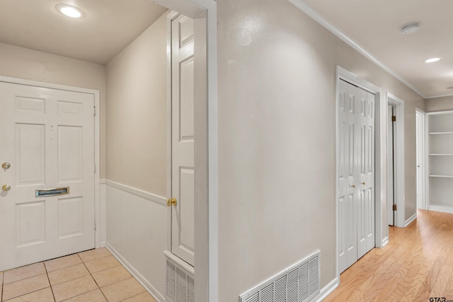 hall with crown molding, recessed lighting, baseboards, and visible vents