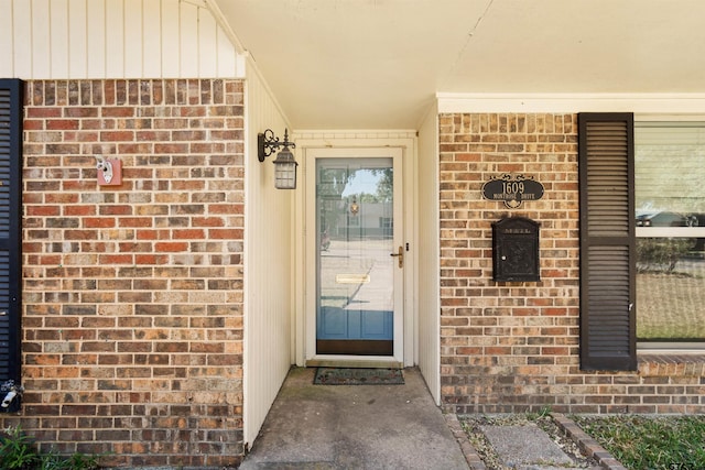 property entrance featuring brick siding and covered porch