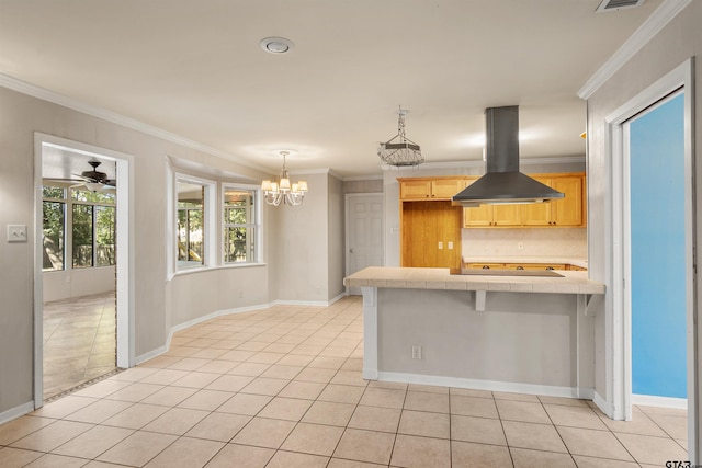 kitchen featuring crown molding, tile countertops, island exhaust hood, and a peninsula