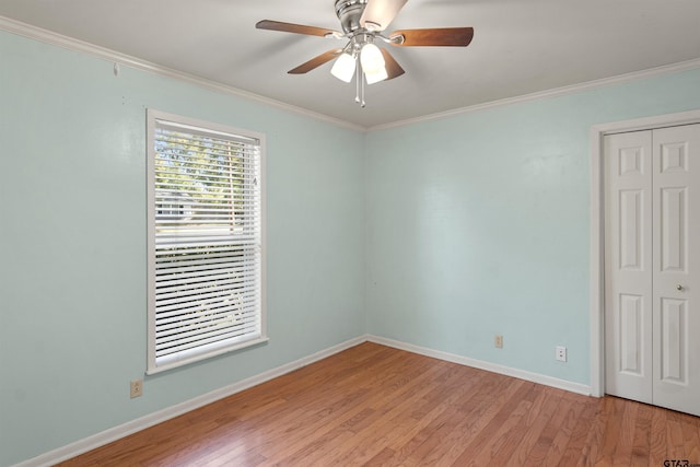 spare room with crown molding, baseboards, light wood-style floors, and a ceiling fan