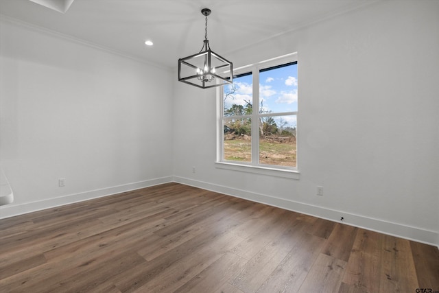 unfurnished dining area featuring a chandelier, crown molding, and dark wood-type flooring