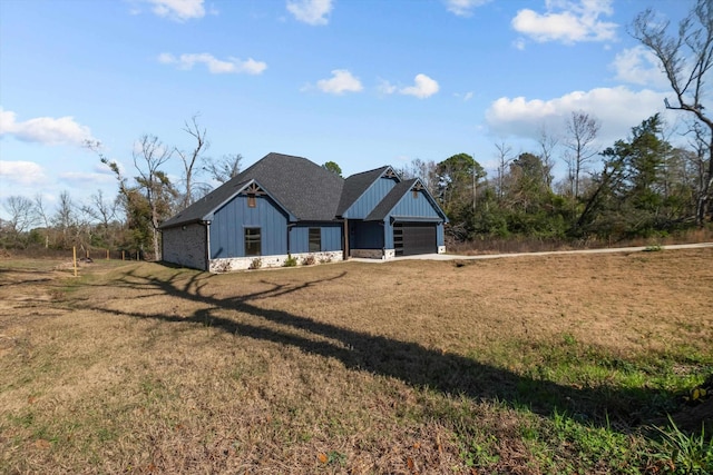 view of front of home with a garage and a front lawn