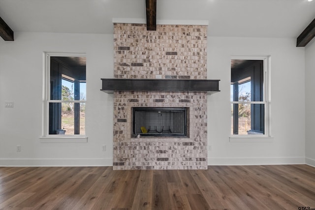 unfurnished living room featuring beam ceiling and wood-type flooring