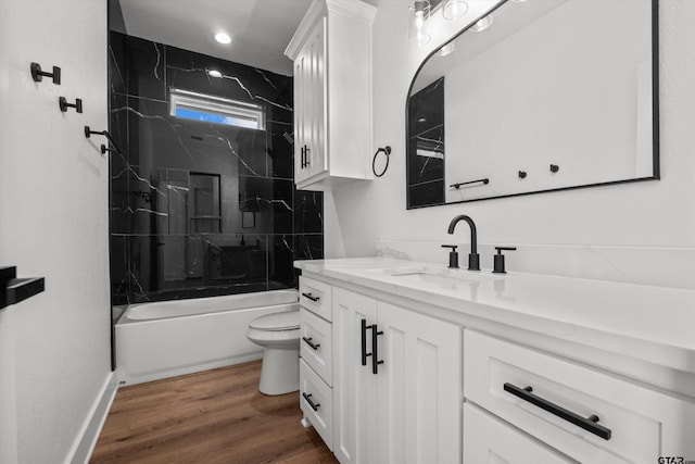 full bathroom with toilet, hardwood / wood-style floors, vanity, and tiled shower / bath