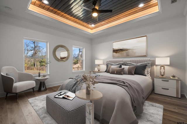 bedroom with ceiling fan, a raised ceiling, dark hardwood / wood-style floors, wood ceiling, and ornamental molding