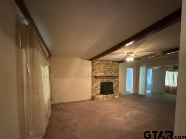 3606 Glendale Dr, Tyler, TX 75701 - unfurnished living room with a ceiling fan, a brick fireplace, beam ceiling, and carpet floors