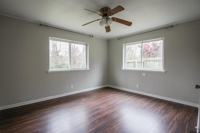 spare room featuring plenty of natural light, dark wood-type flooring, and ceiling fan