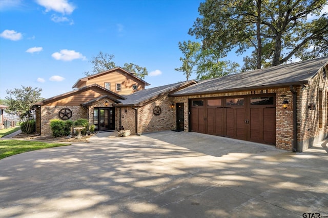 view of front of house featuring brick siding, an attached garage, and driveway