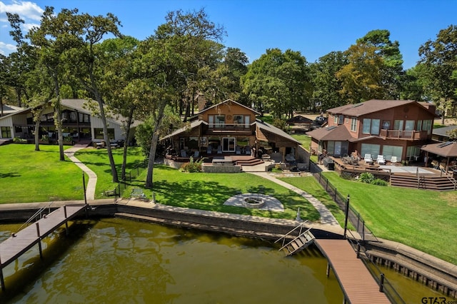 view of dock featuring a residential view, a deck with water view, fence, a yard, and an outdoor fire pit