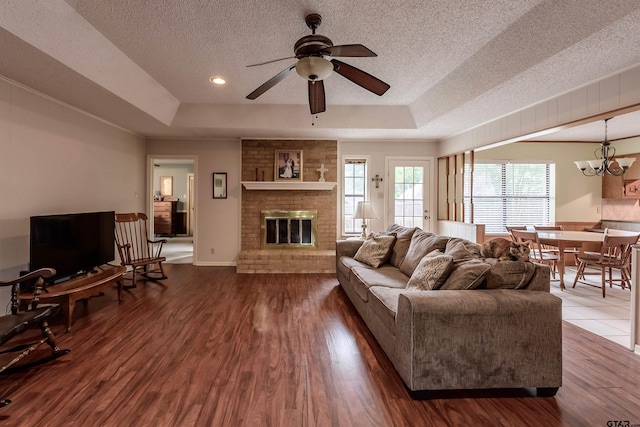 6001 Huntington Dr, Tyler, TX 75703 - living area with a tray ceiling, a textured ceiling, a ceiling fan, wood finished floors, and a chandelier