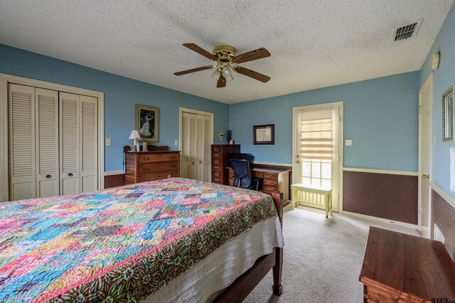 6001 Huntington Dr, Tyler, TX 75703 - bedroom featuring multiple closets, carpet, a textured ceiling, and ceiling fan