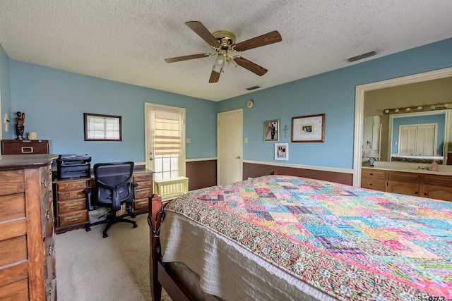 6001 Huntington Dr, Tyler, TX 75703 - carpeted bedroom featuring a textured ceiling, a ceiling fan, a desk, and ensuite bath
