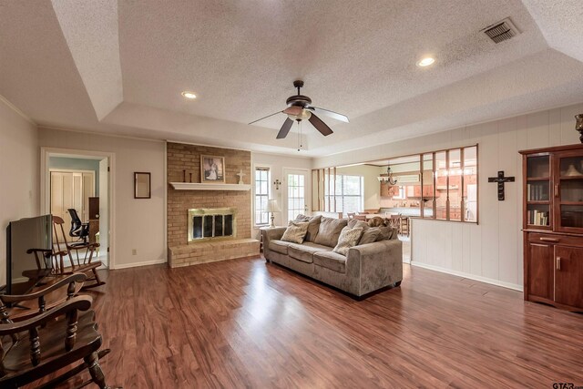 6001 Huntington Dr, Tyler, TX 75703 - living area with a raised ceiling, a textured ceiling, dark wood-style flooring, ceiling fan, and baseboards