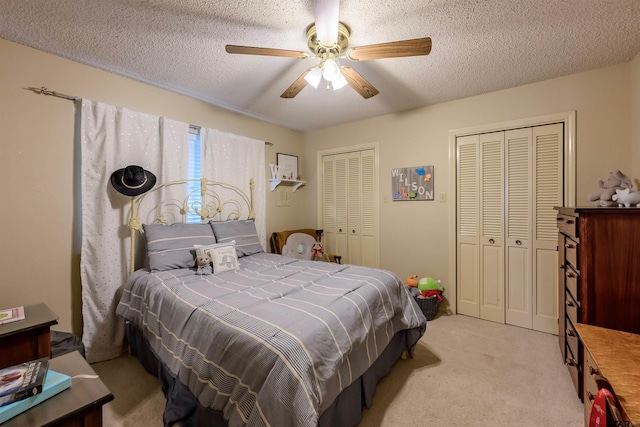 6001 Huntington Dr, Tyler, TX 75703 - bedroom with two closets, light colored carpet, a ceiling fan, and a textured ceiling