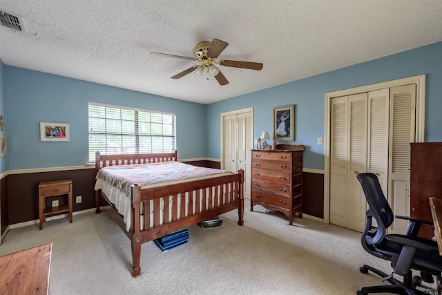 6001 Huntington Dr, Tyler, TX 75703 - bedroom featuring two closets, an office area, carpet flooring, a textured ceiling, and a ceiling fan