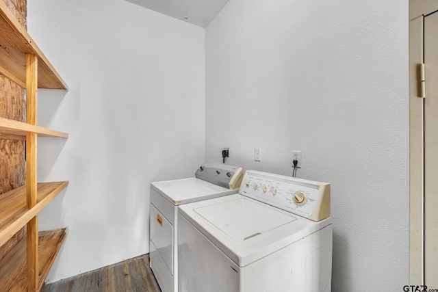 laundry area with washer and dryer and dark wood-type flooring