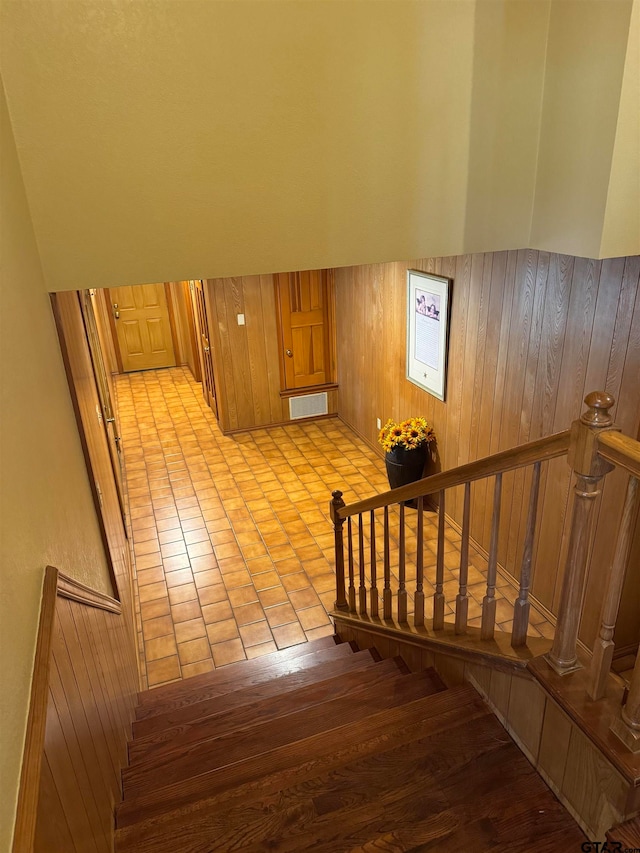 stairway featuring wooden walls and wood-type flooring