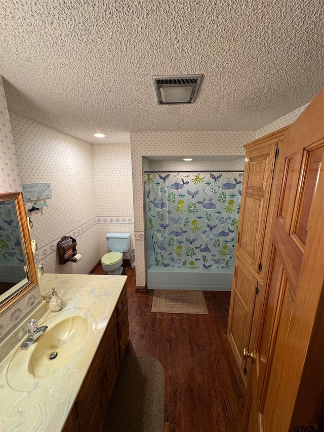 bathroom featuring hardwood / wood-style floors, a textured ceiling, toilet, and vanity