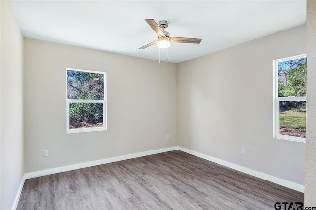 empty room with hardwood / wood-style flooring and ceiling fan