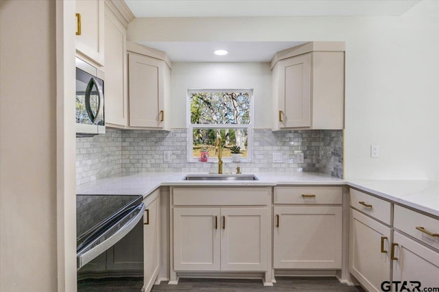 kitchen featuring light stone countertops, electric range, backsplash, and sink