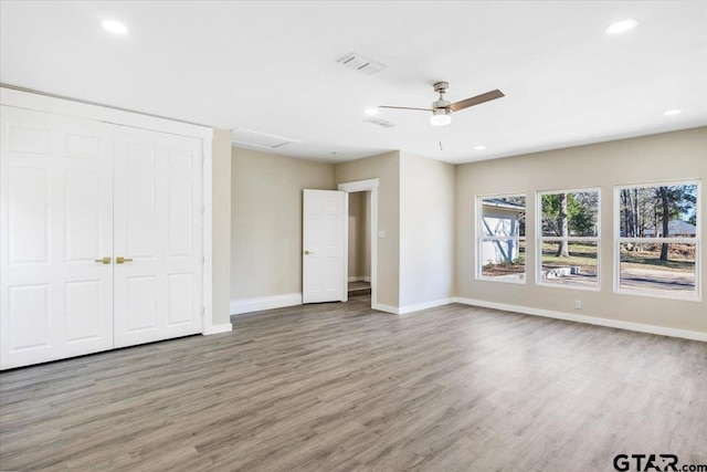 unfurnished bedroom featuring ceiling fan, a closet, and hardwood / wood-style flooring