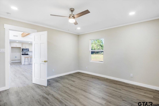 spare room with crown molding, ceiling fan, and light hardwood / wood-style floors