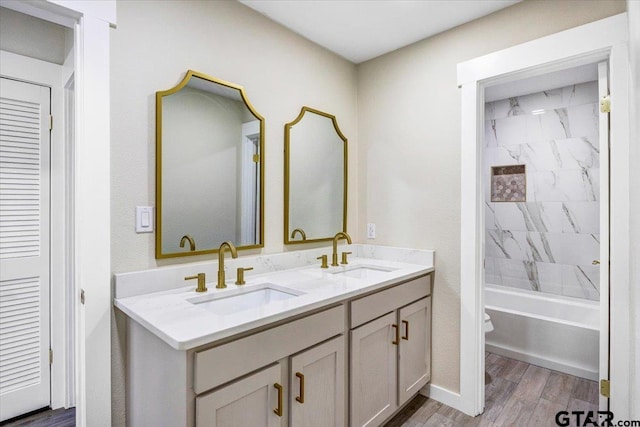 full bathroom featuring vanity, toilet, wood-type flooring, and tiled shower / bath combo